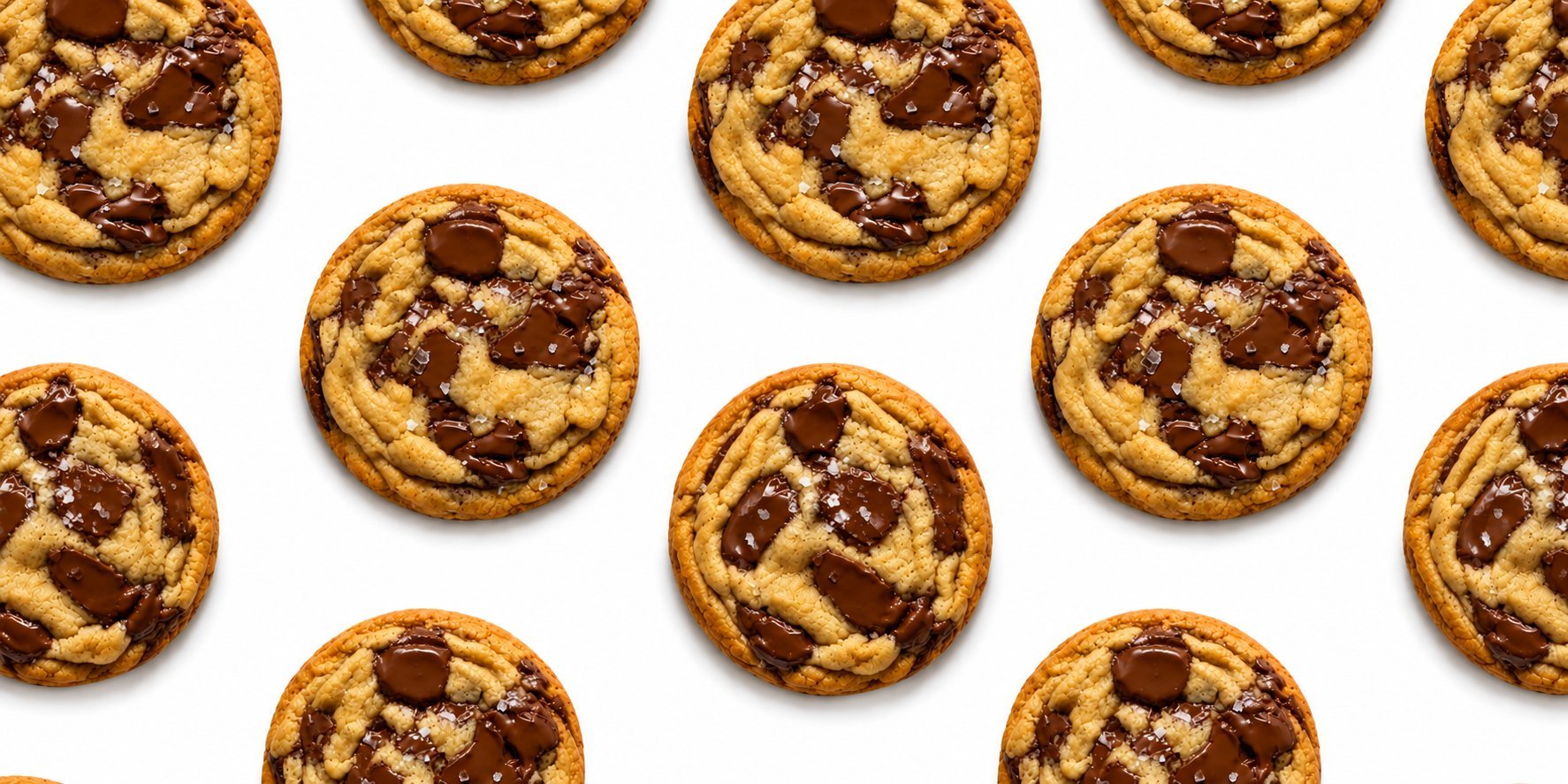 Chocolate chip cookies arranged in rows on white background